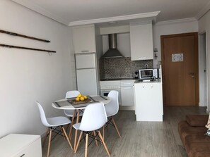 Enjoy cooking and dining in this well-equipped kitchen with a gas stove, microwave, and dining area with a round table and four chairs.