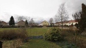 Un barrio residencial con casas, un campo cubierto de hierba y algunos árboles.