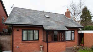 A single-story brick house with a tiled roof, a small front garden, and a visible chimney. - Private detached 3 bedroom bungalow in Preston (Preston)