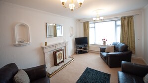 A living room with a fireplace, a television, and leather sofas. - Private detached 3 bedroom bungalow in Preston (Preston)