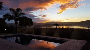 Una piscina al aire libre, sillones reclinables de piscina