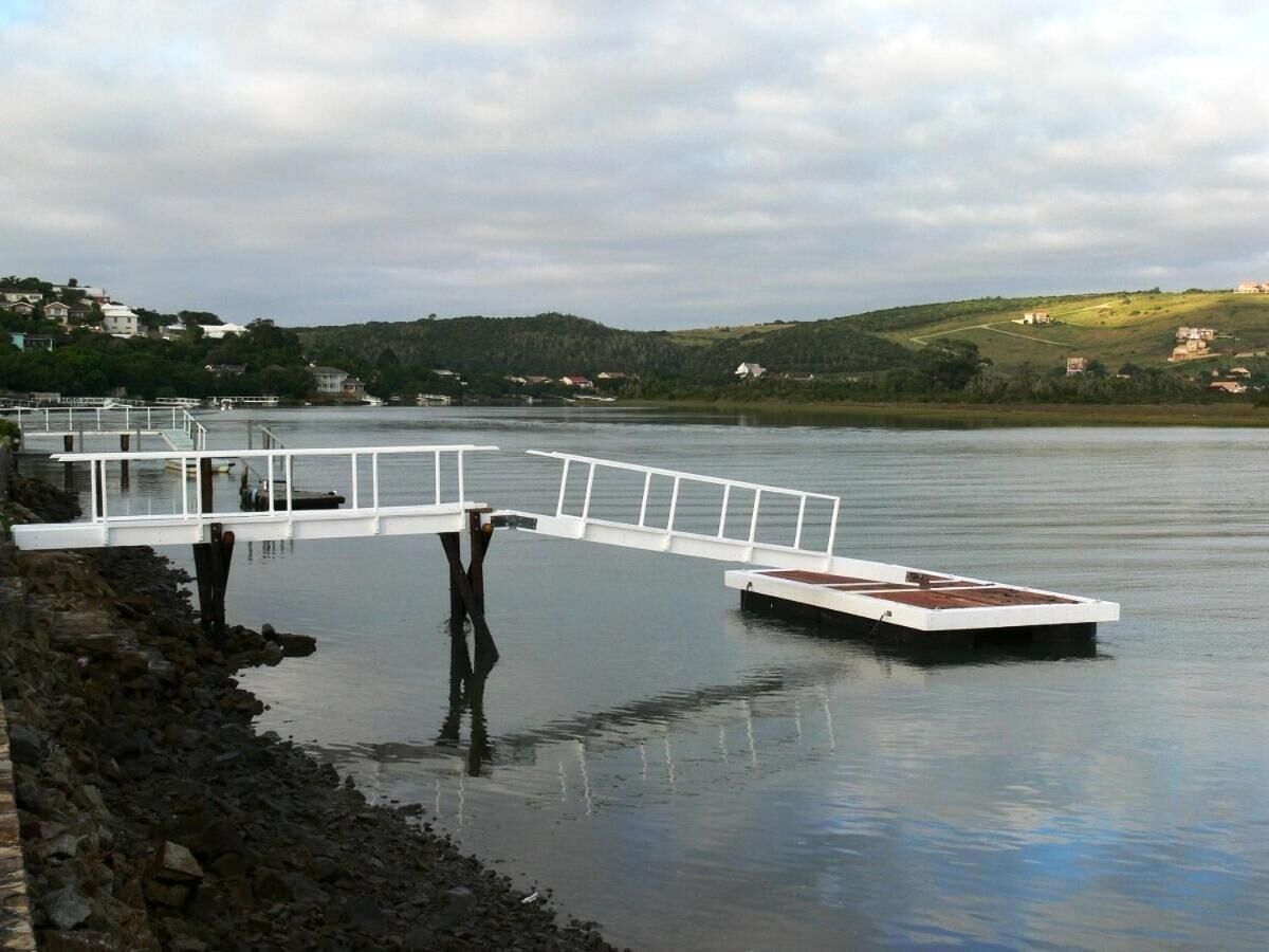 A calm lake with a white pier extending into the water.