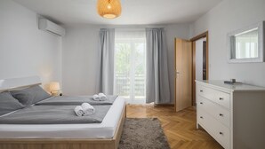 Ein Schlafzimmer mit zwei Betten, einem Schminktisch, einem Spiegel und einem Fenster mit Vorhängen.