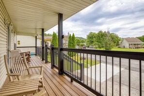 A covered porch with wooden benches and a view of a residential street. - Pigeon Forge One story 3 bedroom Creekside-Enjoy the sounds of the creek- Seasonal Pool Access (Pigeon Forge)