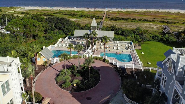 Un resort con dos piscinas, una cancha de tenis y vistas a la playa.