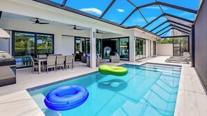 Una piscina interior moderna con techo de cristal, agua azul cristalina y flotadores inflables.