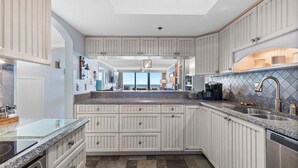 A modern kitchen with white cabinetry, granite countertops, and a view to the outside. - 🌊Breathtaking Ocean ViewsLuxury Penthouse-Daytona Ashley Penthouse 4🌊 (Daytona Beach Shores)