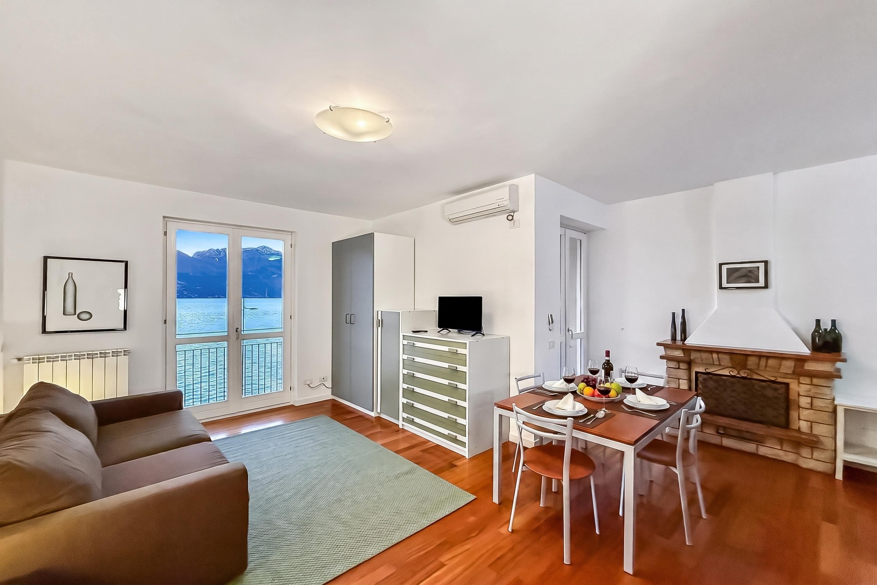 Una sala de estar con un sofá, una mesa de comedor para cuatro personas y una chimenea.