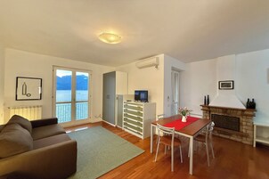 Monolocale familiare, vista montagna, lato lago (Residenza Menaggio - Mimosa) | Area soggiorno | TV a schermo piatto 32 pollici con canali digitali, TV, caminetto