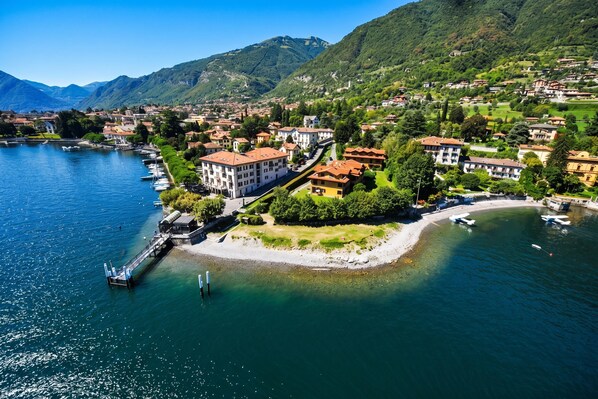 A lakeside town with buildings, boats, and a dock. - Lenno Centrale (Tremezzina)