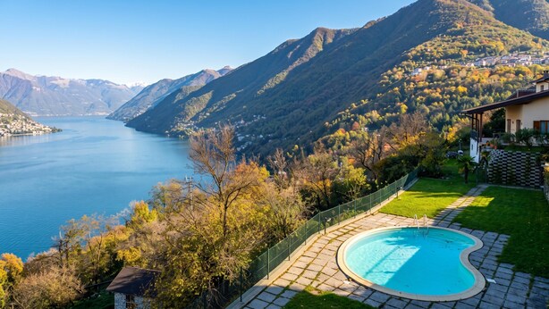 Una piscina con vista su un lago e montagne.