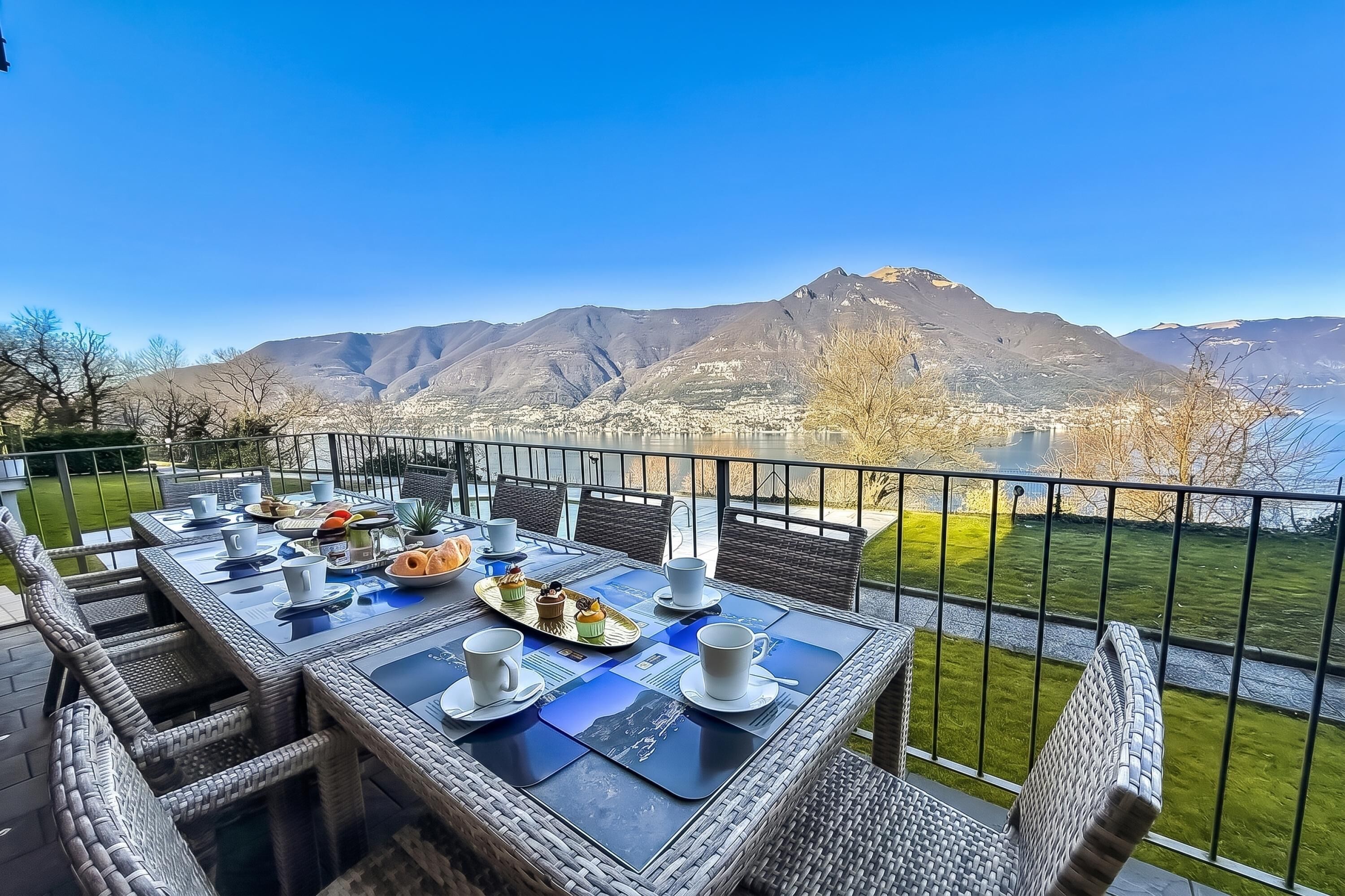 Un espace de restauration en plein air avec une table dressée pour deux personnes, offrant une vue sur un paysage montagneux.