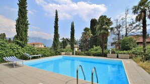 Une piscine rectangulaire dotée de deux échelles métalliques, entourée d’une terrasse carrelée.