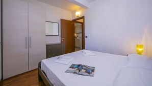 Une chambre à coucher avec un lit, une armoire, un miroir et une lampe de chevet.