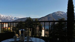 A table with a coffee maker and cups, overlooking a mountain range with a clear sky. - Belvedere Apt. 3 (Tremezzina)