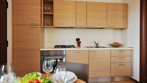 Eine moderne Küche mit Holzschränken, einem Gasherd und einem Spülbecken.
