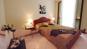 Een hotelkamer met een bed, twee nachtkastjes, een bloevas en een schilderij aan de muur.