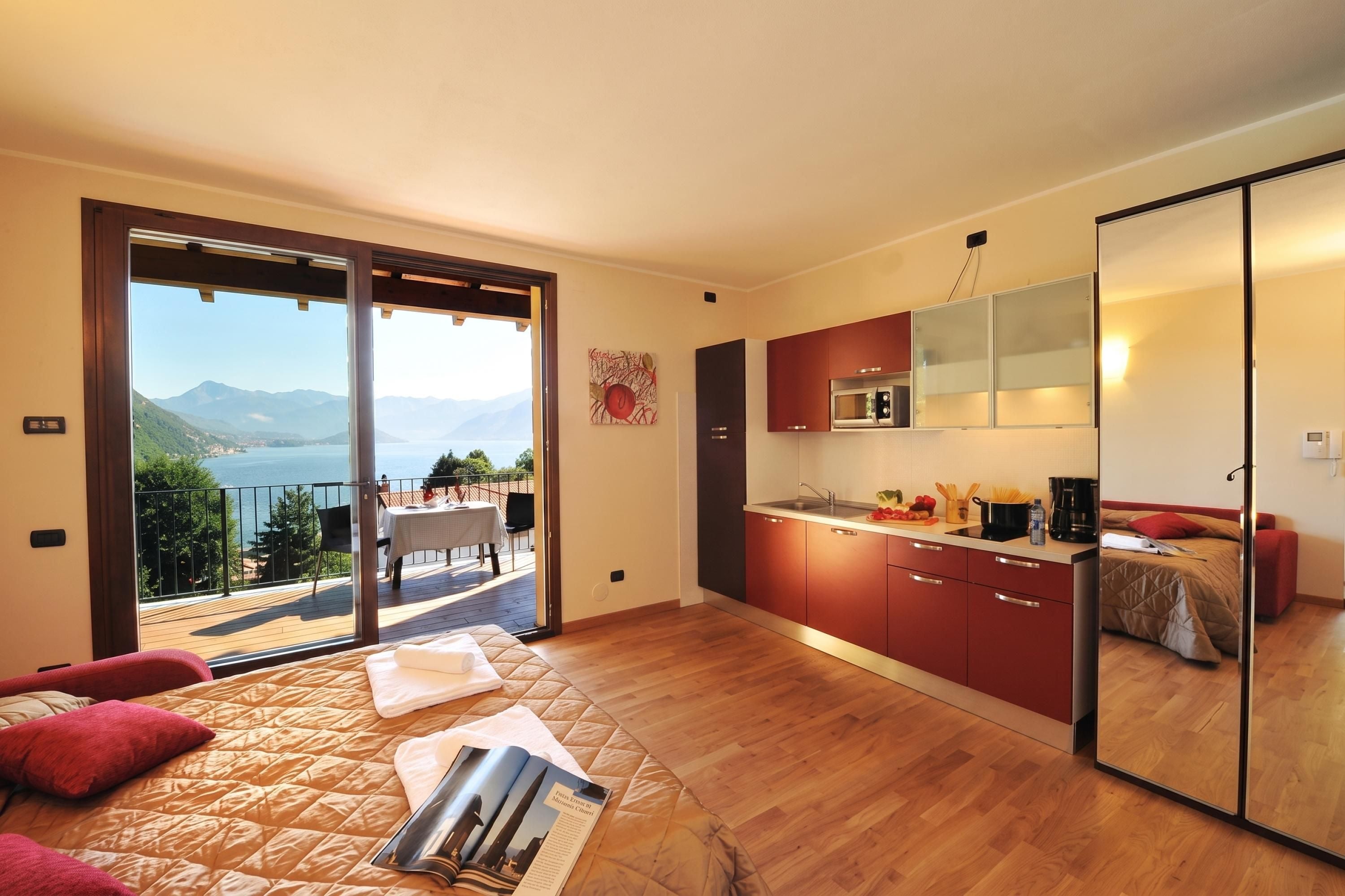 A modern bedroom with a large bed, a view of the sea, and a balcony.