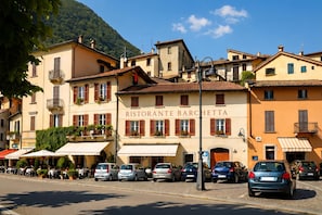 A restaurant named 'Ristorante Barchetta' with outdoor seating and parked cars. - Residence Eden Magnolia 14 (Argegno)