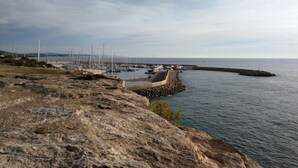 A rocky shoreline with a marina and boats.