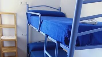 A bunk bed with a blue mattress and metal frame, a wooden ladder, and a white towel on the lower bunk.