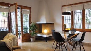 A modern living room with a fireplace, dining table, and chairs. - Beach Apartment Entre Pinos P1 (Torredembarra)