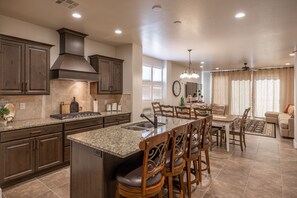 Enjoy meals in the kitchen with a central island and dining area featuring a wooden table and chairs.