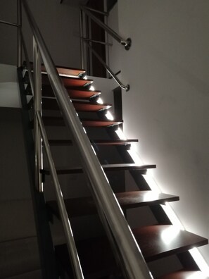 A staircase with a metal railing and wooden steps.