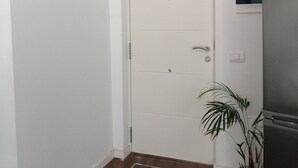 Una puerta blanca con picaporte y un felpudo pequeño en la entrada.