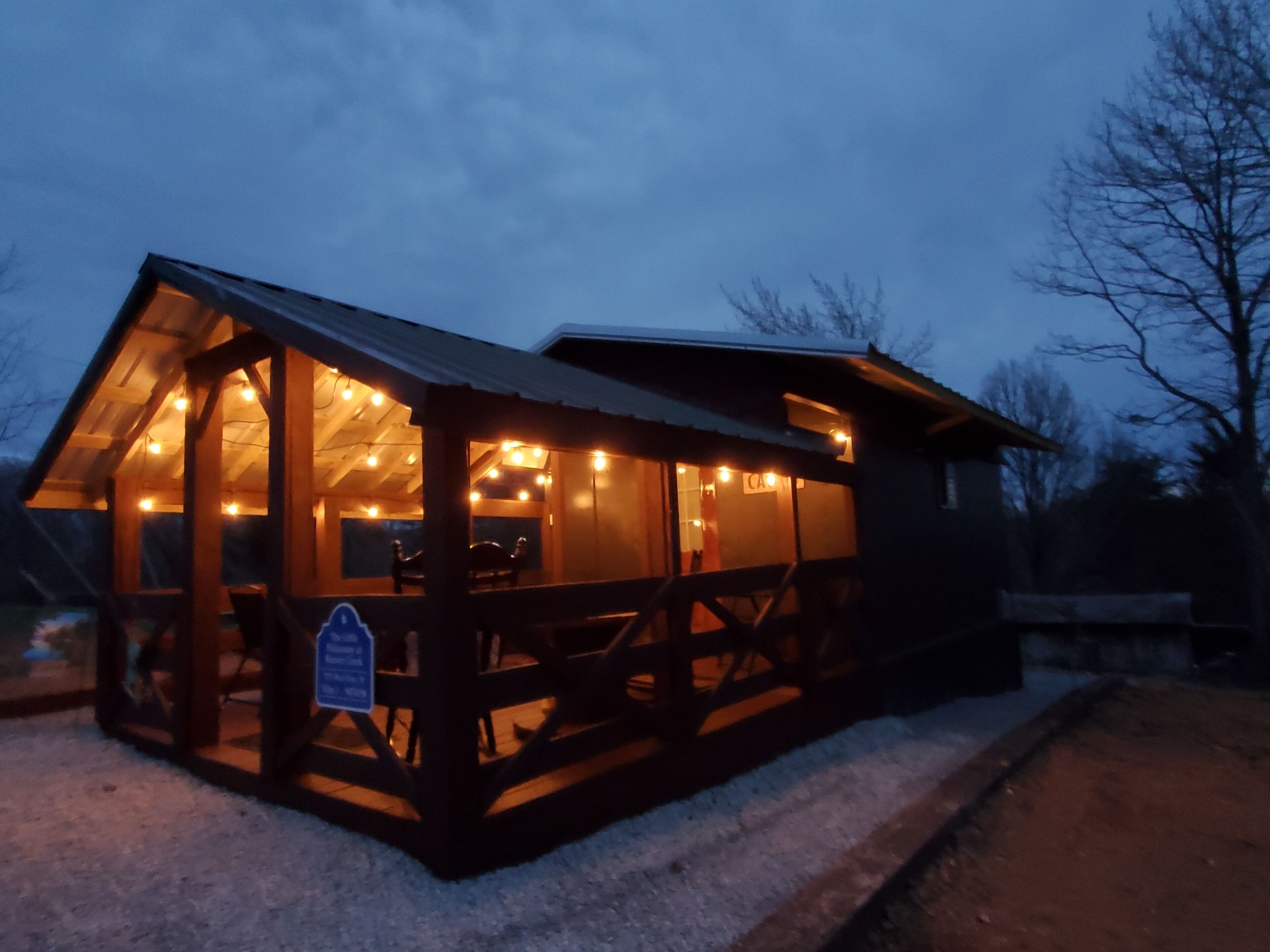 A wooden cabin with a large glass windowed front area, a covered porch, and a sign indicating a restaurant.
