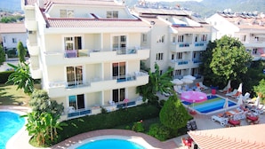 A multi-story hotel with balconies, a swimming pool, and outdoor lounge areas. - Verona Apart Hotel (Marmaris)