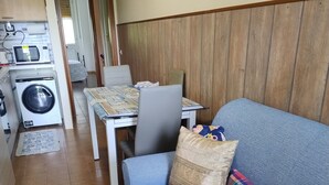 A compact living space with a sofa, a table, and a washing machine.