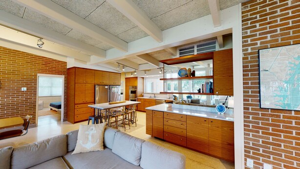 Une cuisine moderne avec des meubles en bois, des appareils en acier inoxydable et un grand îlot central.