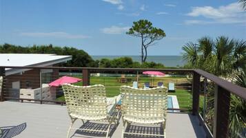 Relax on the balcony with ocean views, a wicker chair, and a small table.