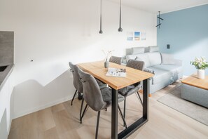 Een moderne woonruimte met een eethoek, een bank en een salontafel.