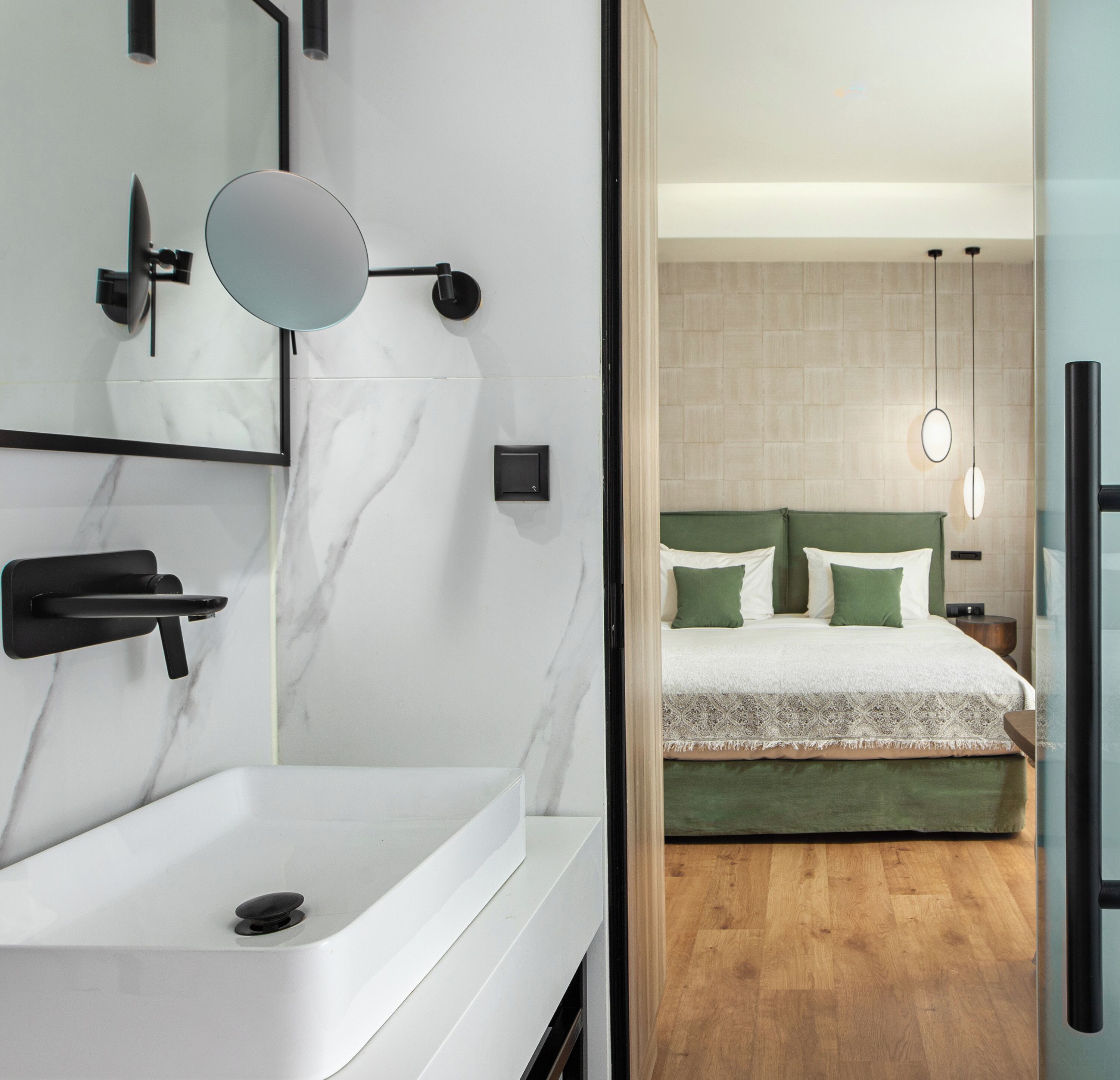 Une salle de bain moderne avec un lavabo blanc, un grand miroir et un porte-serviettes fixé au mur.