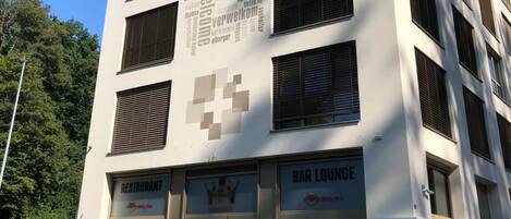 Et hotel i flere etager med et skilt der siger "Hotel Swiss Star" og en ordsky på facaden.