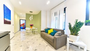 Ein modernes Wohnzimmer mit einer Couch, einem Couchtisch und einem Blumentopf.