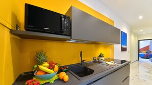 Eine moderne Küche mit einer eingebauten Mikrowelle, einem Spülbecken und einer Obstschale auf der Arbeitsfläche.