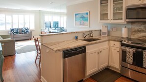 A modern kitchen with white cabinetry, a dishwasher, and a stainless steel oven. - Gated Secluded Marsh View (Johns Island)