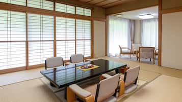 A traditional Japanese room with tatami flooring, a low table, and chairs.
