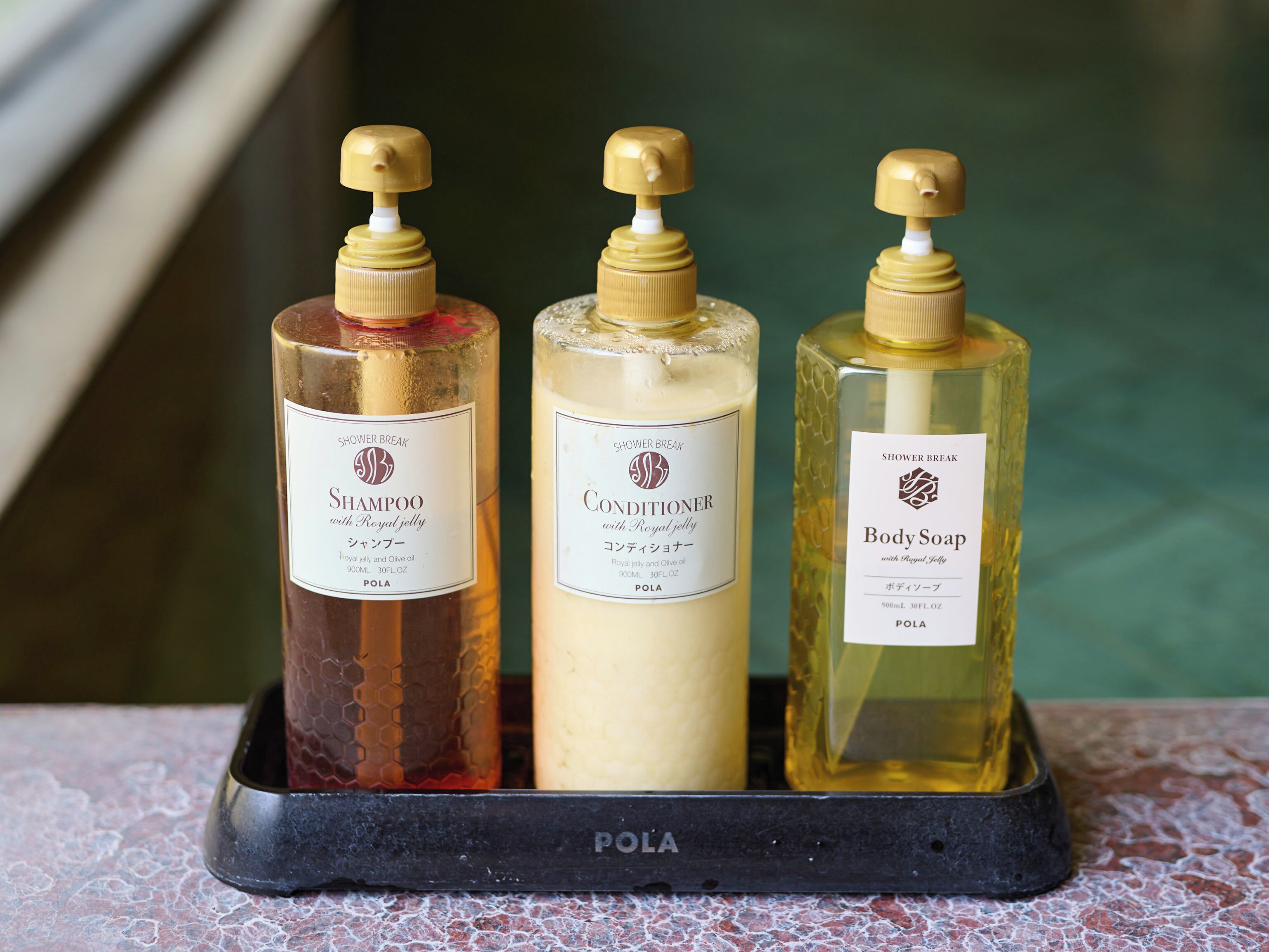 Three bottles of shower products on a tray.
