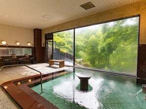 A spa area with a large window, a hot tub, and a seating area.