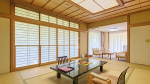 Una habitación tradicional japonesa con suelo de tatami, una mesa baja y puertas correderas shoji.