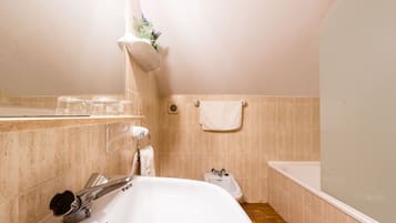Un baño con lavamanos blanco, un bidé, toallero y zona de ducha.
