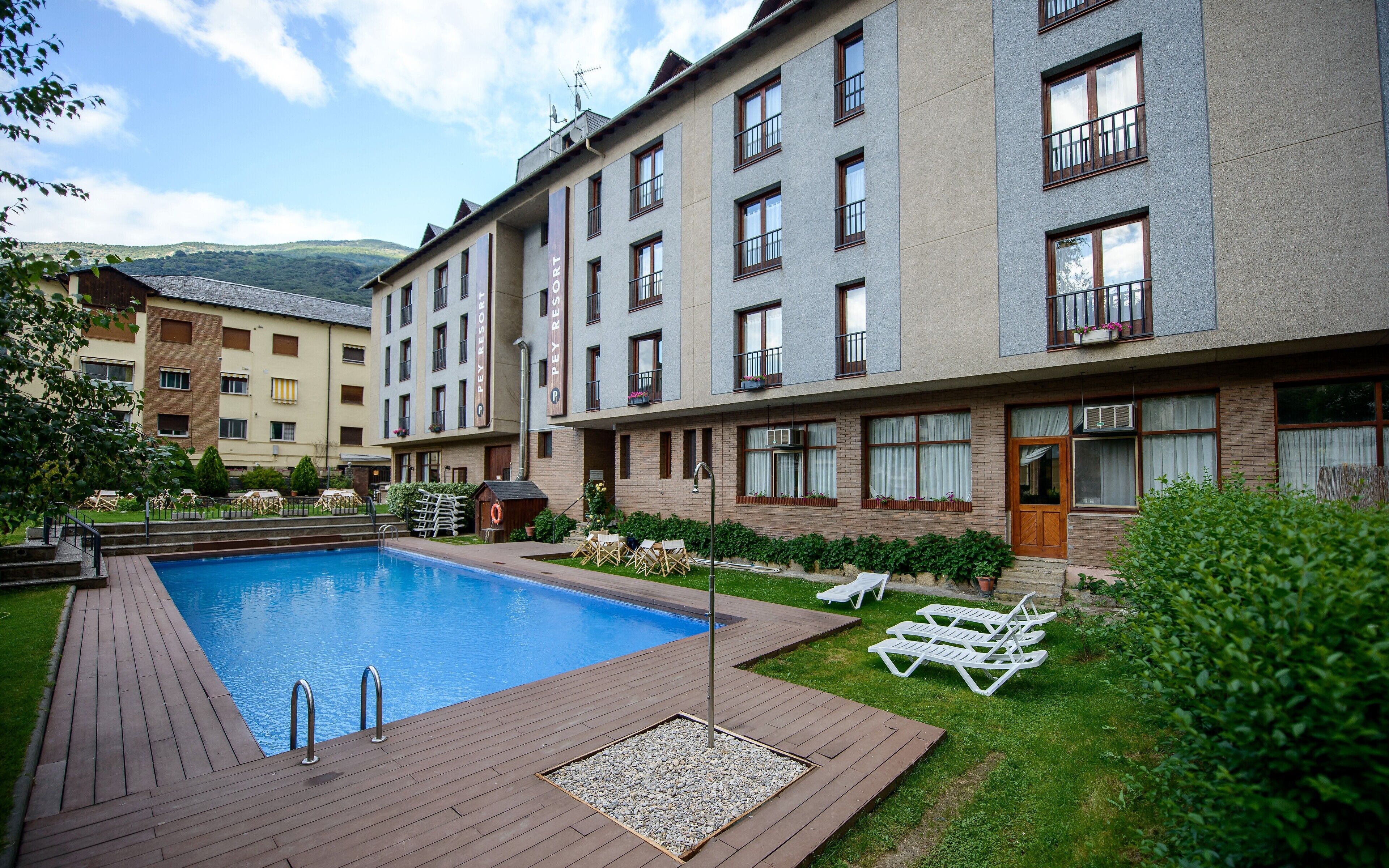 Un hôtel doté d’une piscine, d’un espace extérieur aménagé et offrant une vue sur les montagnes.