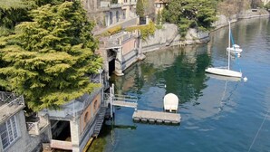 A riverside building with a dock and a boat. - Villa Lucia Laglio with private lake access (Laglio)