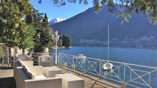 A waterfront terrace with outdoor seating and a view of a lake and mountains. - Villa Lucia Laglio with private lake access (Laglio)