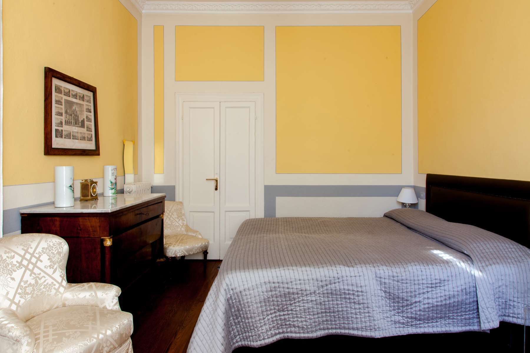 Une chambre à coucher avec un lit, une chaise, un bureau et une porte.