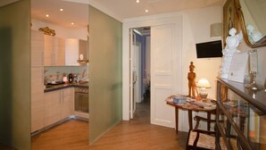 A modern kitchen with wooden cabinets, a built-in oven, and a dining area with a table and chairs.